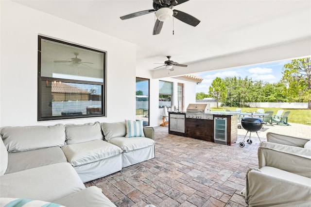 view of patio featuring an outdoor living space with a fire pit, area for grilling, ceiling fan, a grill, and wine cooler