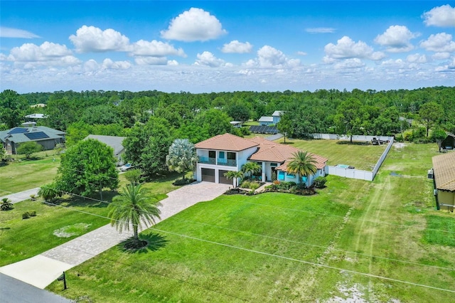 aerial view of property and surrounding area with a heavily wooded area