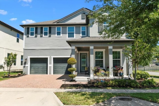 14639 Winter Stay Dr, Winter Garden, FL 34787 - view of front of house with covered porch, an attached garage, decorative driveway, and stucco siding
