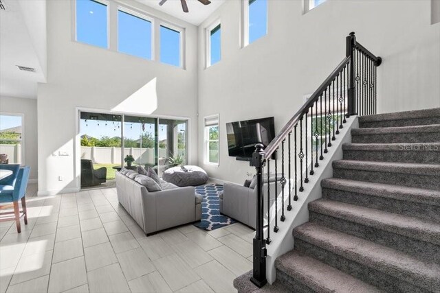 14639 Winter Stay Dr, Winter Garden, FL 34787 - living area featuring a ceiling fan, a towering ceiling, stairway, and baseboards