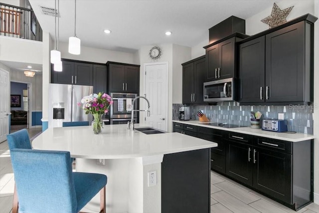 14639 Winter Stay Dr, Winter Garden, FL 34787 - kitchen featuring a sink, stainless steel appliances, tasteful backsplash, a spacious island, and hanging light fixtures