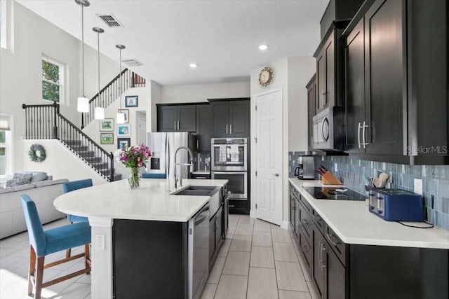 14639 Winter Stay Dr, Winter Garden, FL 34787 - kitchen with appliances with stainless steel finishes, a sink, decorative backsplash, light countertops, and decorative light fixtures