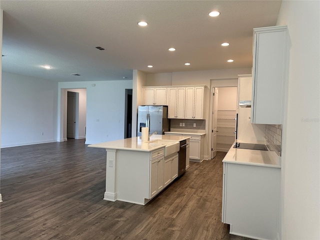 kitchen with stainless steel appliances, recessed lighting, dark wood finished floors, a sink, and a center island with sink