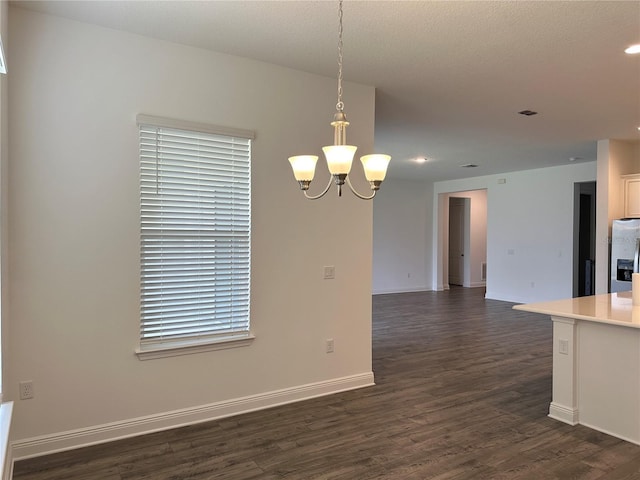 unfurnished dining area with a chandelier, dark wood-style floors, recessed lighting, and baseboards
