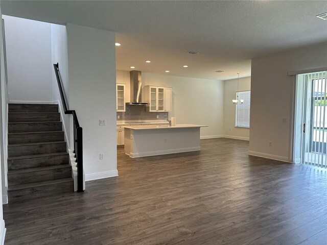 living room featuring dark wood finished floors, baseboards, recessed lighting, stairway, and a chandelier
