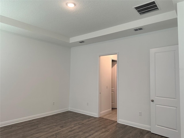 unfurnished room with dark wood-type flooring, baseboards, and a textured ceiling