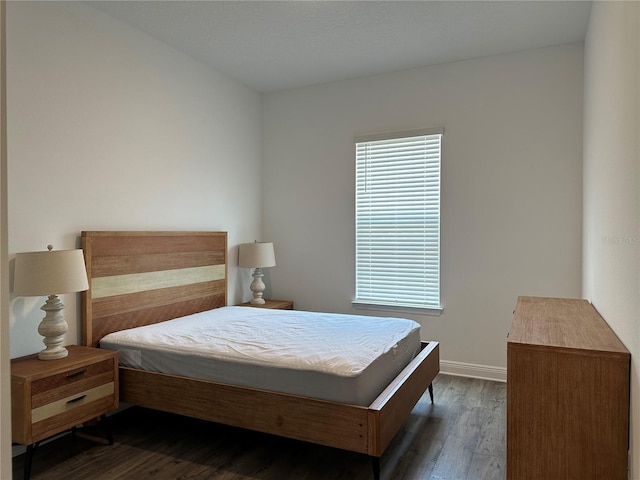 bedroom featuring dark wood finished floors and baseboards