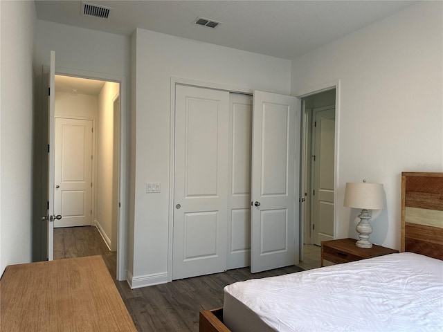 bedroom featuring dark wood finished floors, a closet, and baseboards