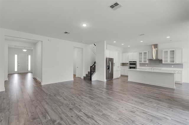 15161 Lake Bessie Loop, Winter Garden, FL 34787 - unfurnished living room with stairs, wood finished floors, recessed lighting, baseboards, and a sink