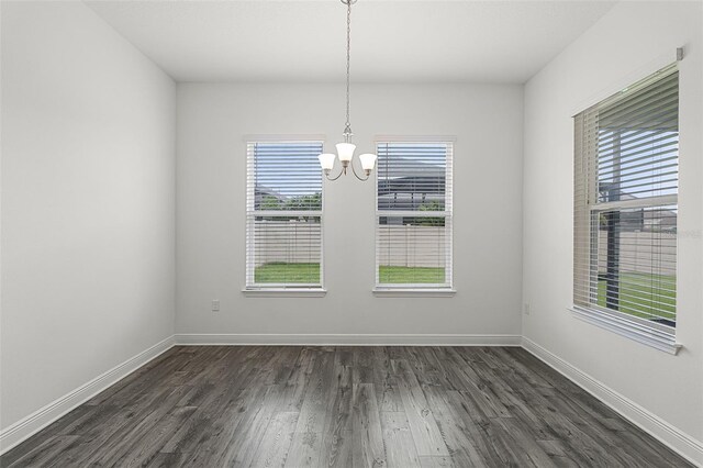 15161 Lake Bessie Loop, Winter Garden, FL 34787 - unfurnished dining area with a chandelier, healthy amount of natural light, dark wood-style flooring, and baseboards