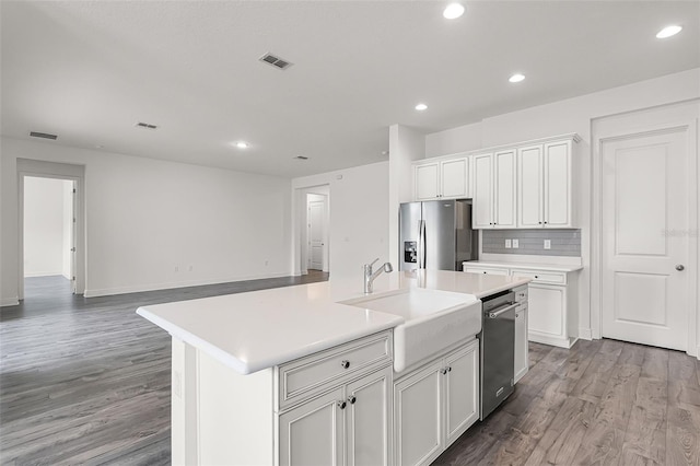 15161 Lake Bessie Loop, Winter Garden, FL 34787 - kitchen featuring stainless steel appliances, a sink, light countertops, wood finished floors, and recessed lighting