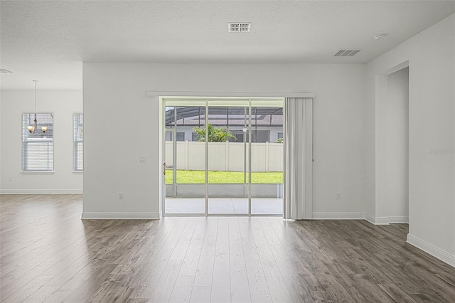 15161 Lake Bessie Loop, Winter Garden, FL 34787 - empty room featuring wood finished floors, baseboards, a chandelier, and a textured ceiling