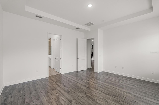 15161 Lake Bessie Loop, Winter Garden, FL 34787 - unfurnished bedroom featuring dark wood finished floors, recessed lighting, baseboards, a raised ceiling, and ensuite bathroom