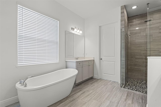 15161 Lake Bessie Loop, Winter Garden, FL 34787 - bathroom featuring a stall shower, vanity, a freestanding tub, baseboards, and recessed lighting