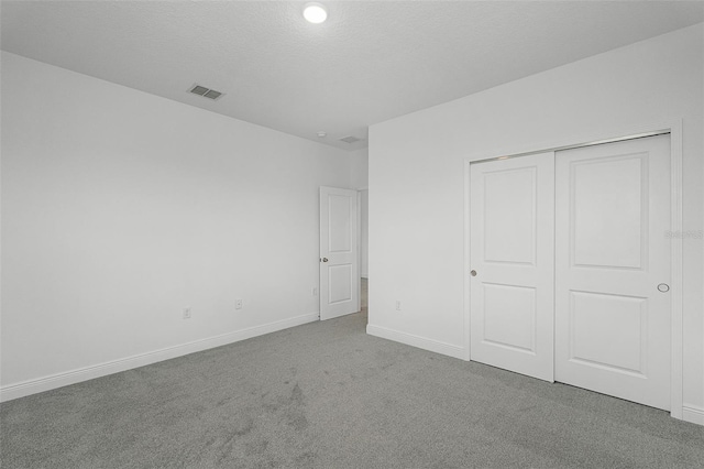 15161 Lake Bessie Loop, Winter Garden, FL 34787 - unfurnished bedroom featuring carpet flooring, baseboards, a closet, and a textured ceiling