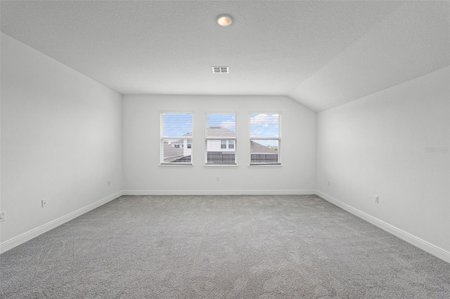 15161 Lake Bessie Loop, Winter Garden, FL 34787 - carpeted spare room with baseboards, a textured ceiling, and vaulted ceiling