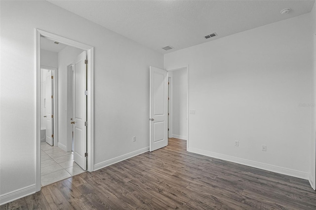 15161 Lake Bessie Loop, Winter Garden, FL 34787 - unfurnished bedroom with dark wood finished floors, baseboards, and connected bathroom
