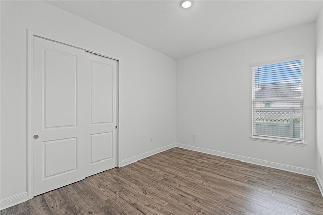 15161 Lake Bessie Loop, Winter Garden, FL 34787 - unfurnished bedroom with wood finished floors, baseboards, and a closet
