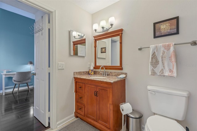 6057 Lake Pointe Dr Unit 408, Orlando, FL 32822 - bathroom with baseboards, toilet, wood finished floors, and vanity