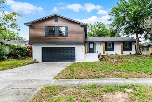 7085 Willowwood St, Orlando, FL 32818 - split level home featuring an attached garage, driveway, a front lawn, and brick siding