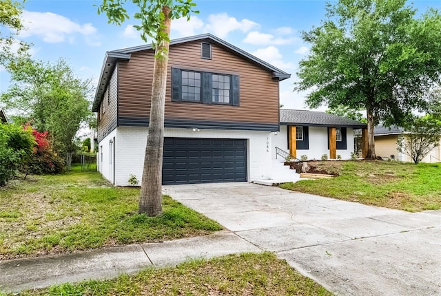 7085 Willowwood St, Orlando, FL 32818 - tri-level home featuring brick siding, a garage, concrete driveway, and a front lawn
