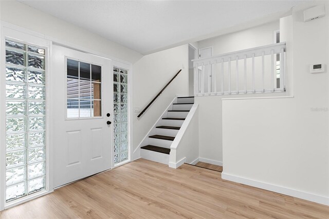 7085 Willowwood St, Orlando, FL 32818 - foyer entrance featuring stairway, light wood-style flooring, and baseboards