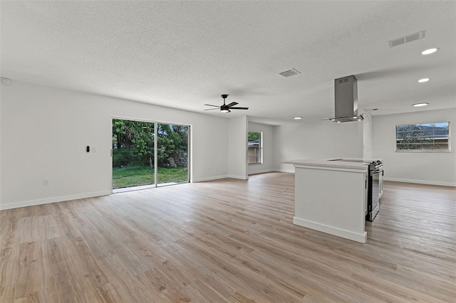 7085 Willowwood St, Orlando, FL 32818 - unfurnished living room featuring a textured ceiling, ceiling fan, light wood finished floors, baseboards, and recessed lighting