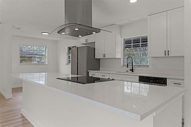 7085 Willowwood St, Orlando, FL 32818 - kitchen with a sink, island exhaust hood, black electric cooktop, dishwasher, and freestanding refrigerator