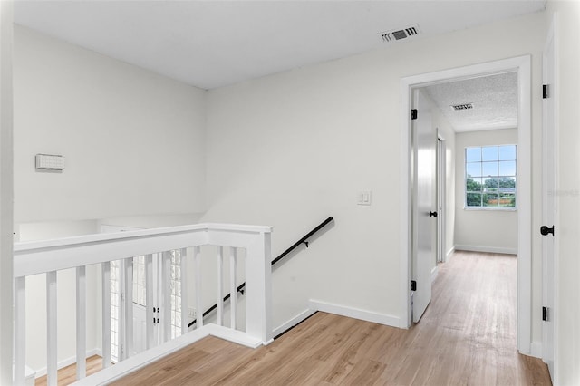 7085 Willowwood St, Orlando, FL 32818 - hall with an upstairs landing, light wood finished floors, and baseboards