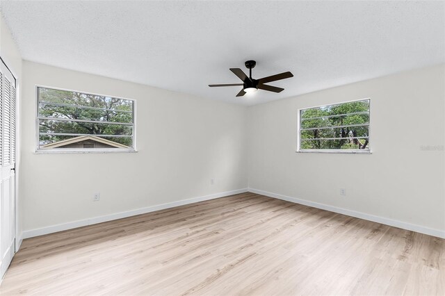 7085 Willowwood St, Orlando, FL 32818 - unfurnished room featuring wood finished floors, plenty of natural light, and baseboards