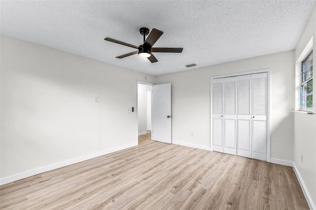7085 Willowwood St, Orlando, FL 32818 - unfurnished bedroom featuring wood finished floors, a closet, baseboards, a textured ceiling, and a ceiling fan
