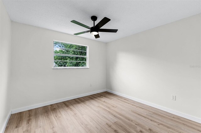 7085 Willowwood St, Orlando, FL 32818 - unfurnished room with wood finished floors, a ceiling fan, baseboards, and a textured ceiling