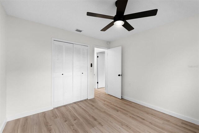 7085 Willowwood St, Orlando, FL 32818 - unfurnished bedroom featuring light wood-style floors, baseboards, a closet, and ceiling fan