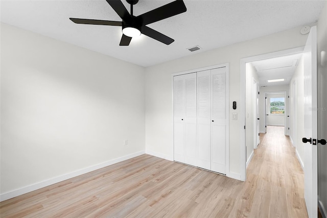 7085 Willowwood St, Orlando, FL 32818 - unfurnished bedroom featuring light wood-style flooring, a closet, baseboards, ceiling fan, and attic access