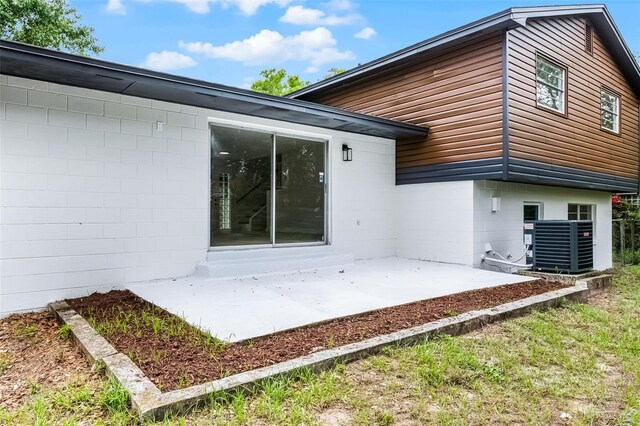 7085 Willowwood St, Orlando, FL 32818 - back of house with a patio area, cooling unit, and concrete block siding