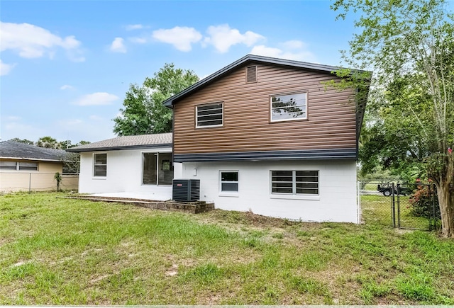 7085 Willowwood St, Orlando, FL 32818 - back of property featuring central AC unit, a patio area, and a gate