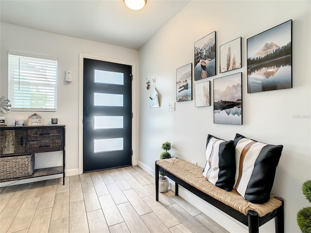 foyer entrance featuring light wood-style flooring and baseboards