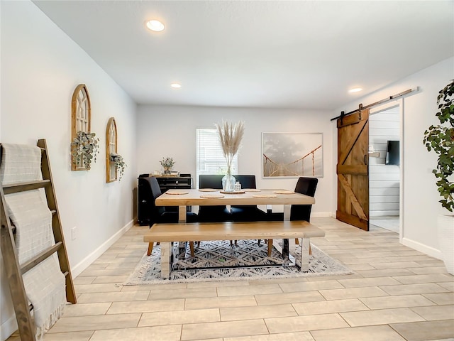dining space featuring a barn door, recessed lighting, baseboards, and light wood-style floors