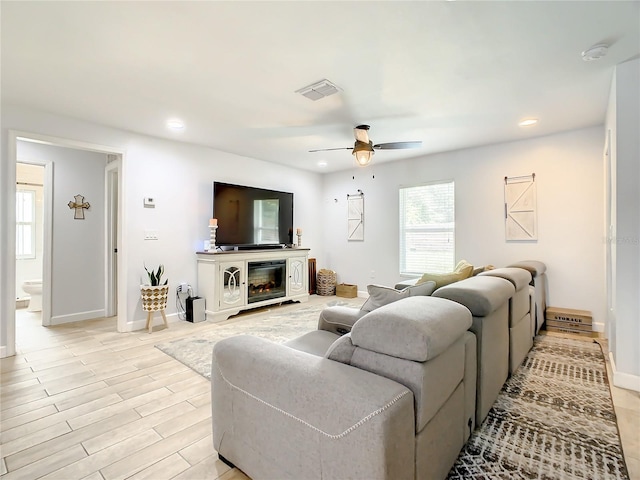 living room featuring a ceiling fan, recessed lighting, and baseboards