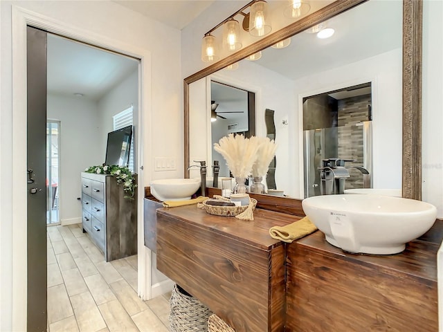 bathroom featuring vanity, ceiling fan, baseboards, and a shower