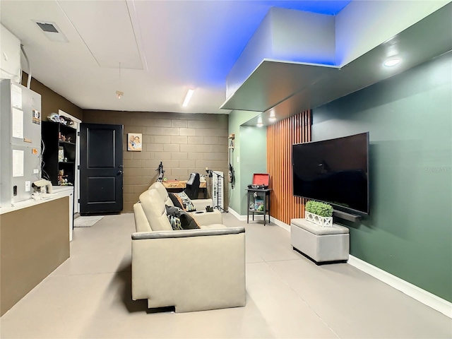 living room featuring finished concrete flooring and attic access