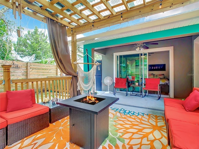 view of patio with an outdoor living space with a fire pit, fence, and a pergola