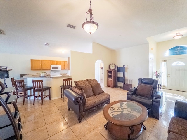 212 Ashford Dr, Davenport, FL 33837 - living area featuring arched walkways, light tile patterned floors, and vaulted ceiling