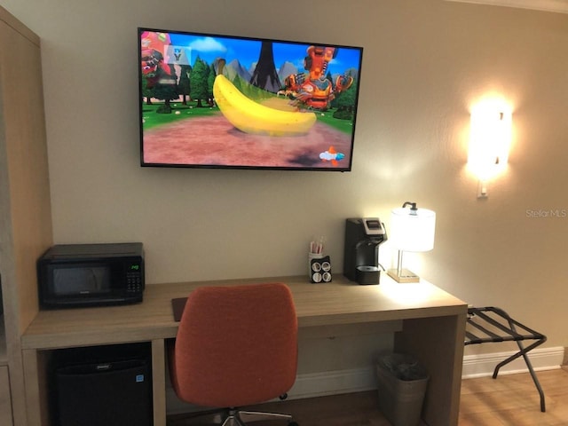 office space with baseboards and wood finished floors