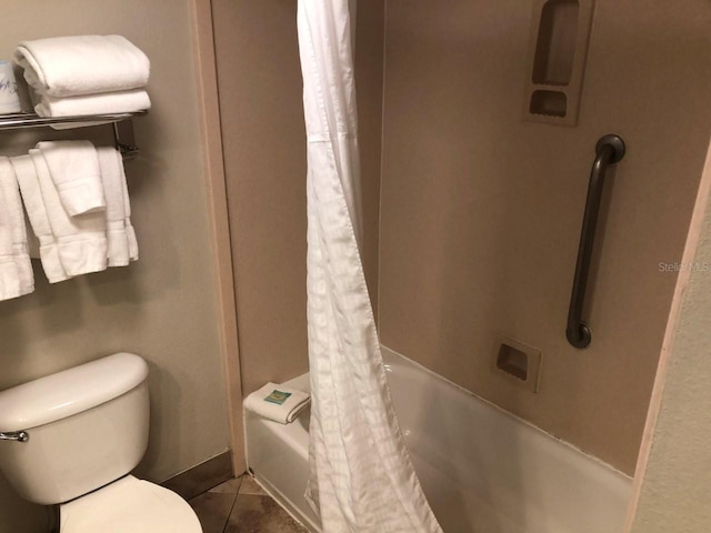 full bath with tile patterned flooring, shower / tub combo, and toilet