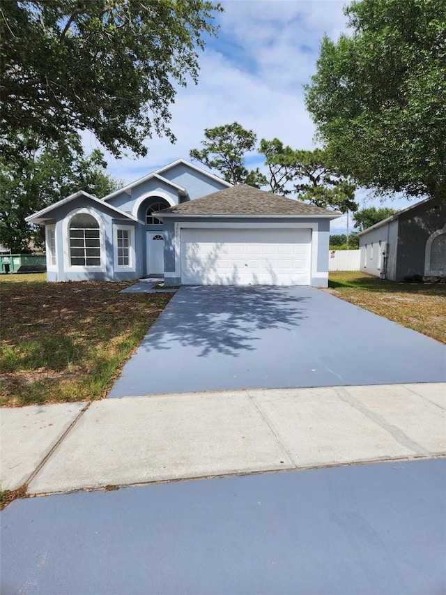 ranch-style house with driveway, stucco siding, and an attached garage