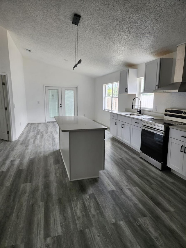 kitchen with electric range, wall chimney exhaust hood, a sink, a textured ceiling, and dark wood finished floors