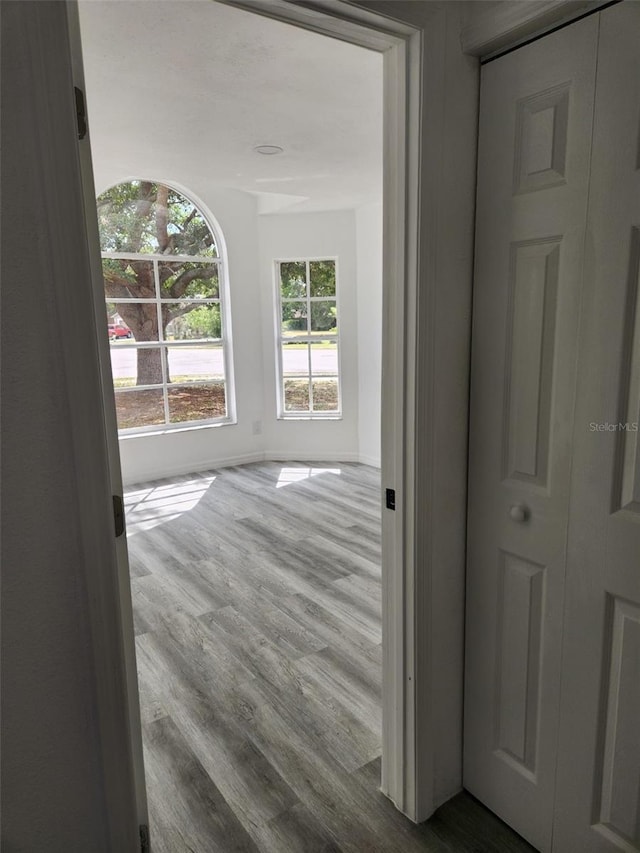 corridor featuring dark wood-style flooring and baseboards