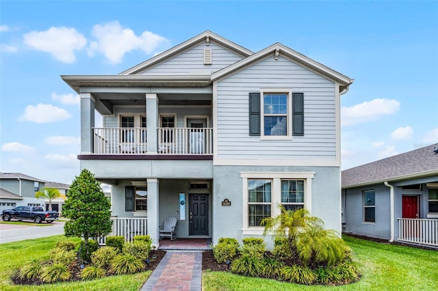 16484 Angel Fish Rd, Winter Garden, FL 34787 - view of front facade with a balcony, a porch, a front lawn, and stucco siding