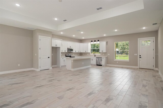 12460 SW 48 Lane Rd, Ocala, FL 34481 - kitchen featuring stainless steel appliances, open floor plan, a center island, white cabinets, and recessed lighting